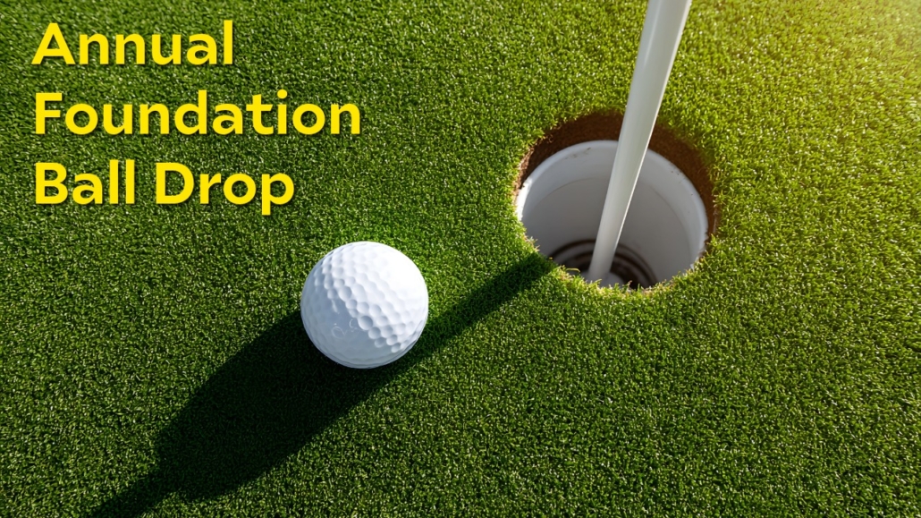 Golf ball on green next to cup