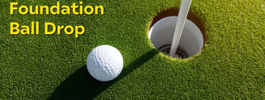 Golf ball on green next to cup